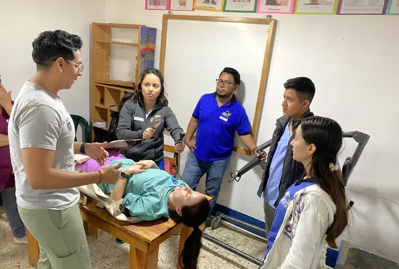 People being instructed on assistant a patient.