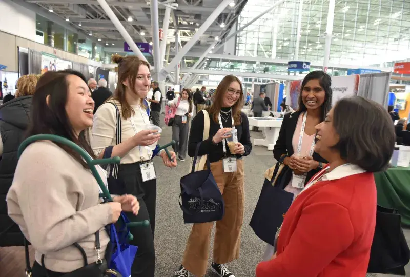 Five people standing and laughing