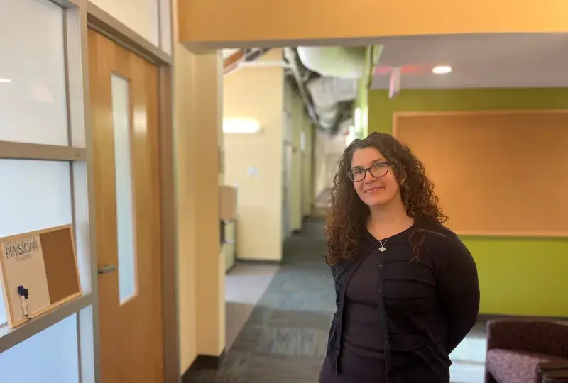 woman smiles and poses in hallway