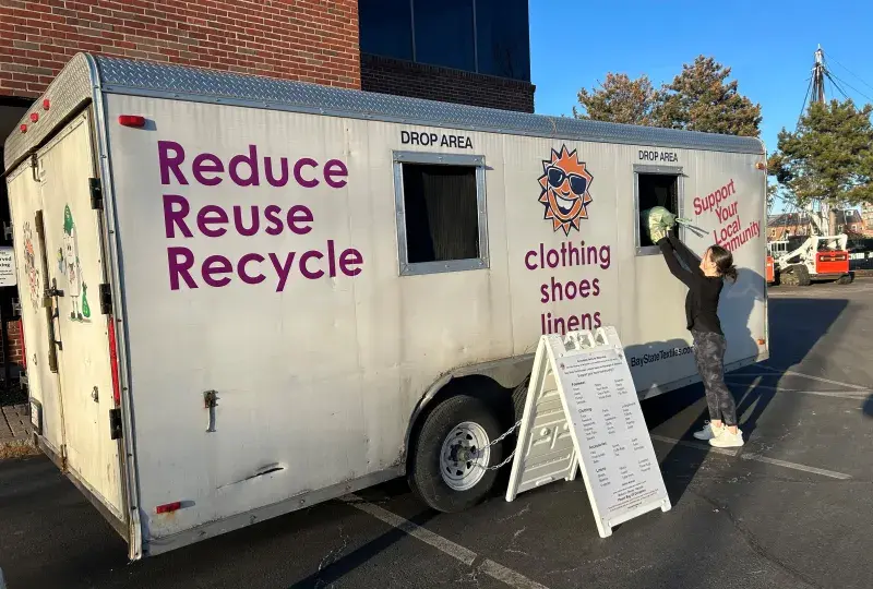 woman stands at textile drive truck