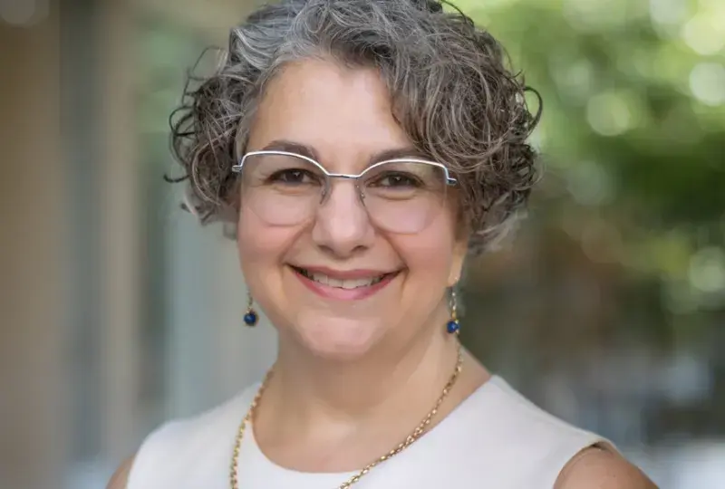 terry has silver rimmed glasses and curly grey hair