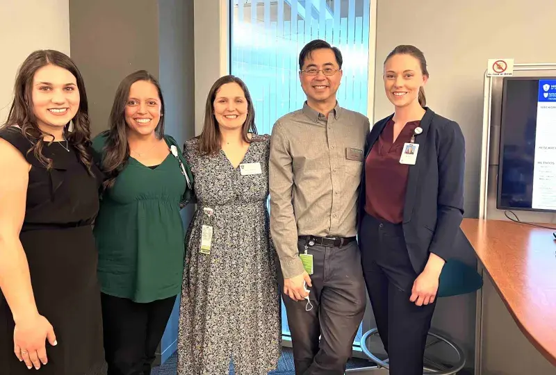 5 people standing and smiling