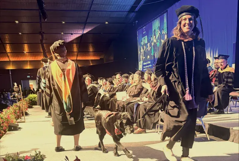 Woman and dog walk across stage