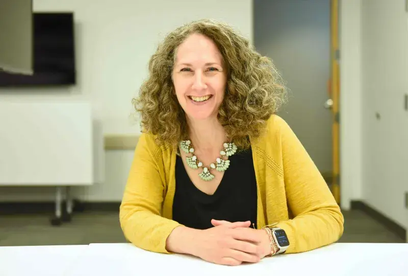 Woman smiling sitting at table in conference room
