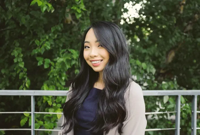 Woman smiles standing outside