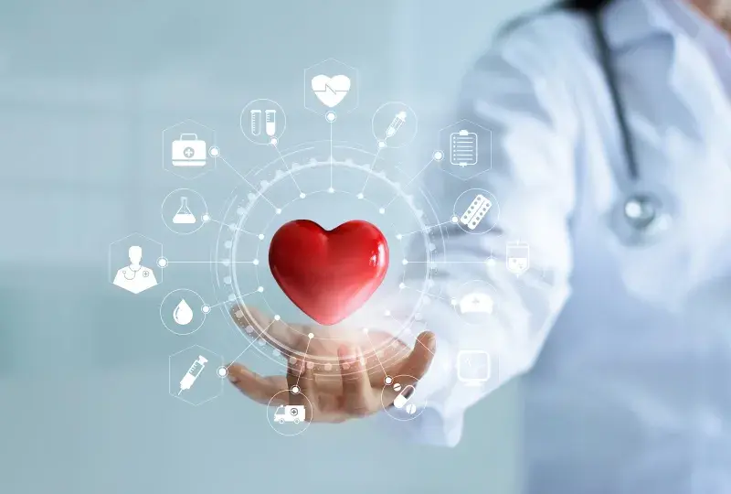 red heart floats above the hand of someone wearing a white lab coat