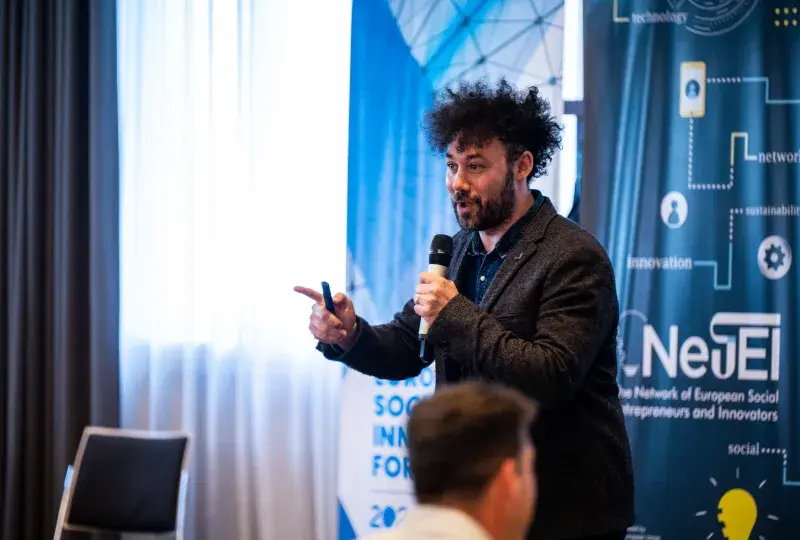 Man speaking to crowd with microphone 