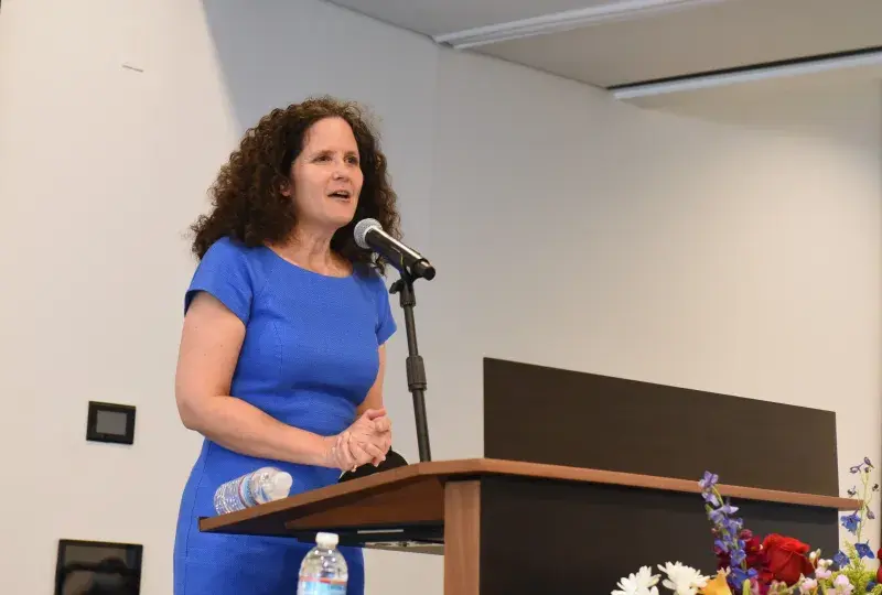 A woman speaks at a podium