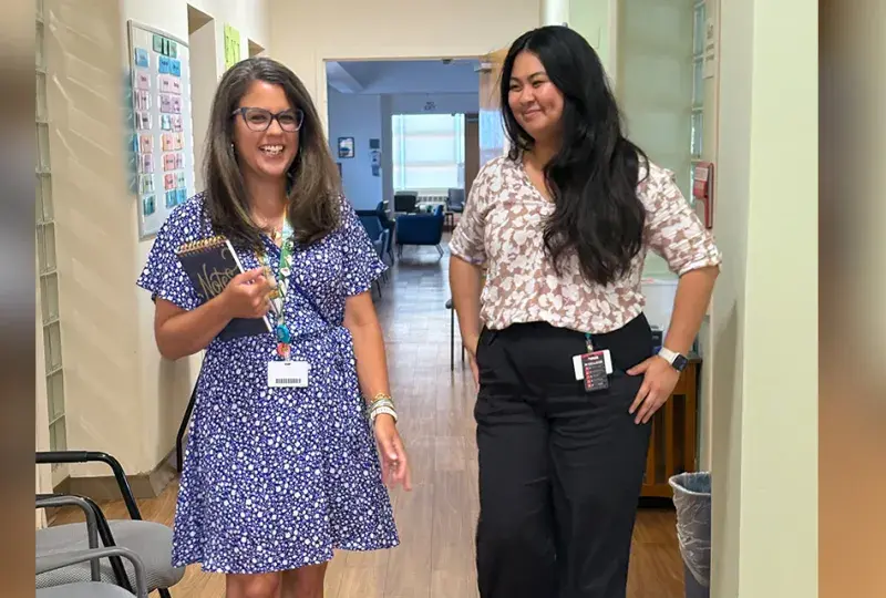 two women walking in hallway 