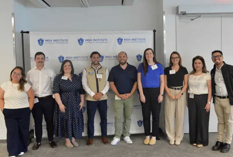 9 people in front of a background that says MGH Institute