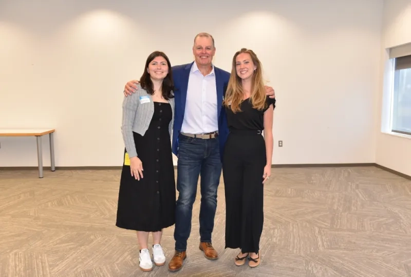 Three people stand next to each other 