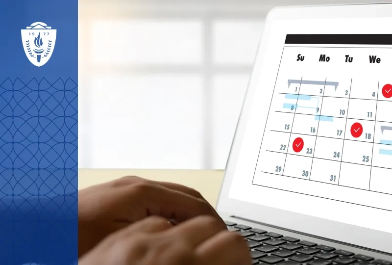 Laptop with a full screen calendar displayed. A person's hands are typing on the keys.
