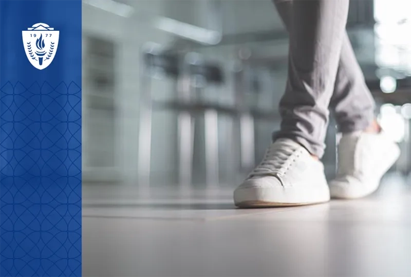 Close up of someone walking in white sneakers and wearing gray pants