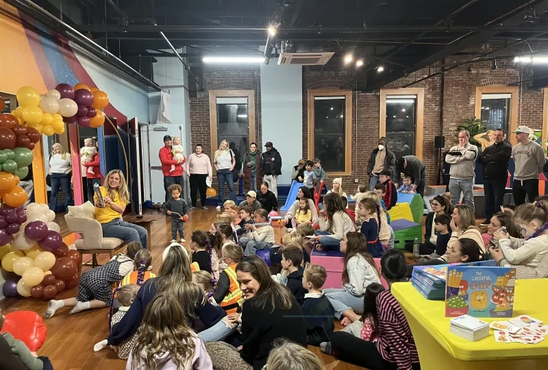 Woman reads book in front of crowd