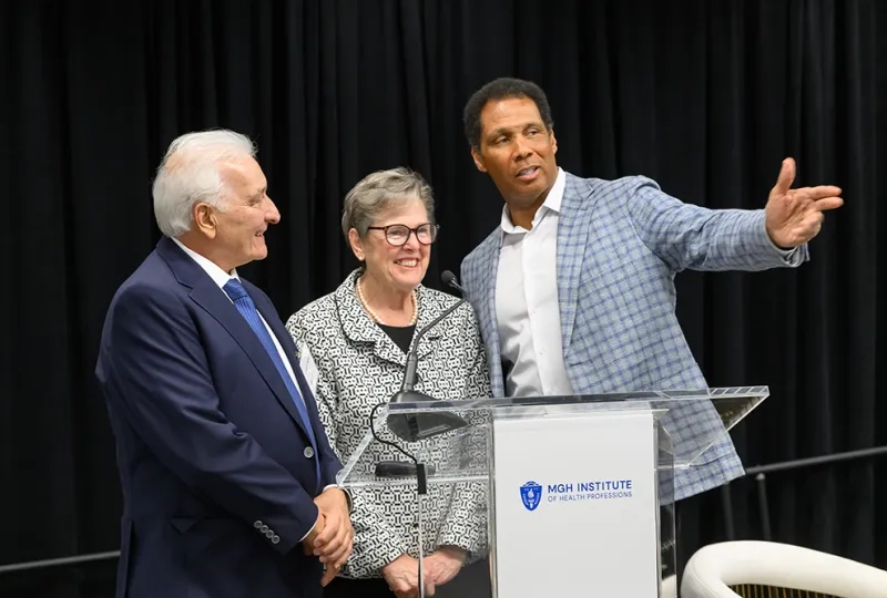 Three people stand behind a podium