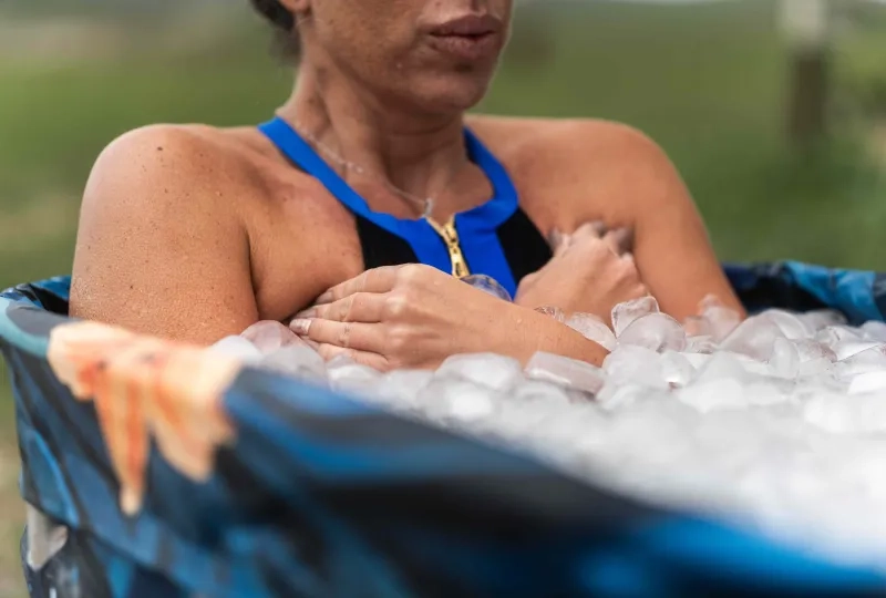 Woman sitting in a tub of ice. 