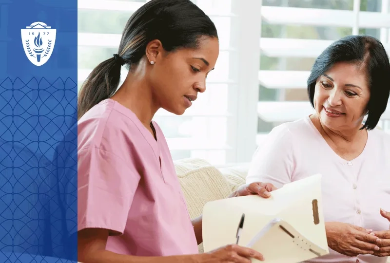 Nurse in pink scrubs looking a printed document with patient.