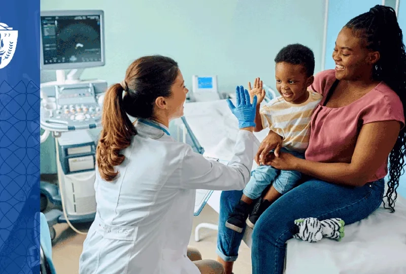 Mother and her child sitting in exam room while the nurse high fives the child