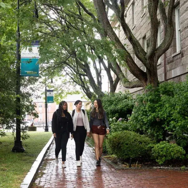 Three young women walking on a Boston path.
