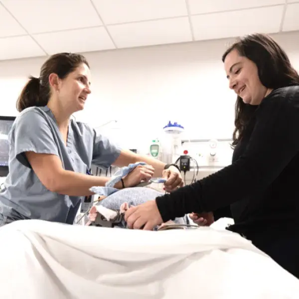 Nursing students in the MGH IHP Direct-Entry Master's in Nursing Program practicing patient care skills. This program offers an accelerated pathway to a nursing career, emphasizing nursing practice specializations and leadership roles.