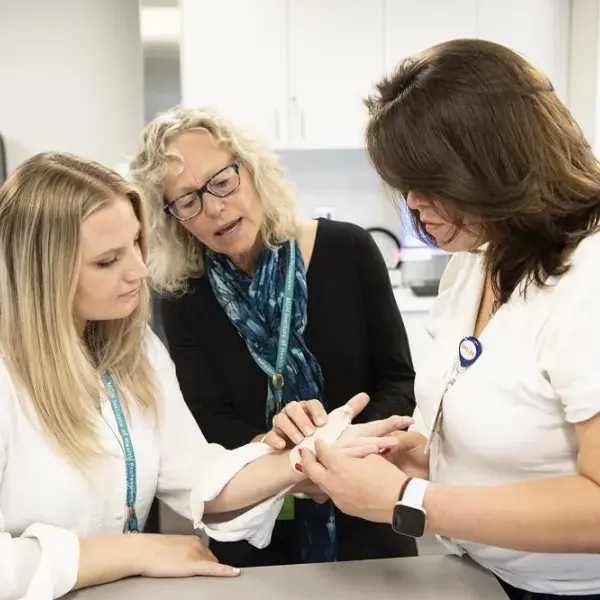 woman looks at splint on another woman's hand