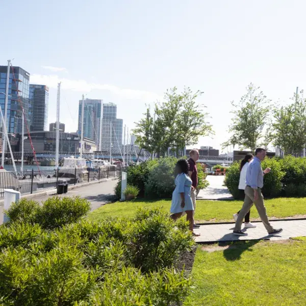 People walking in a park with the waterfront in the backround
