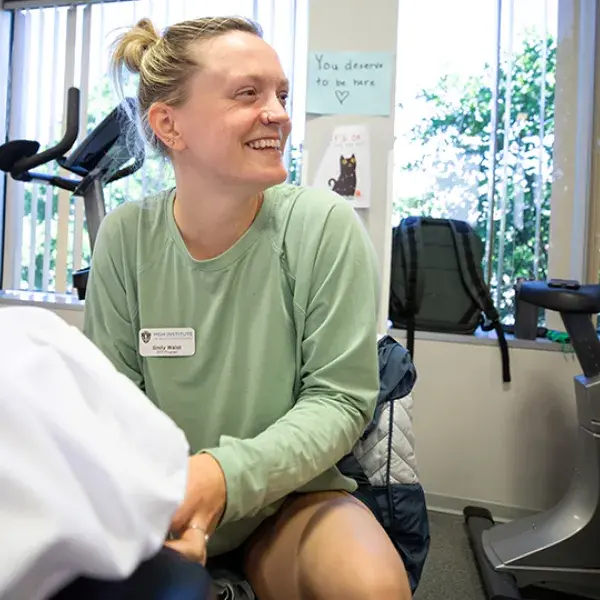 woman looks to the side as she works on a foot