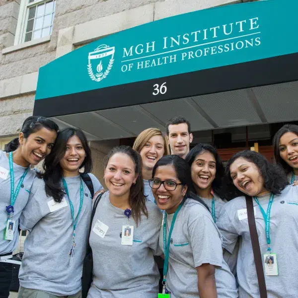 group of female and one male student smile for the camera in matching shirts