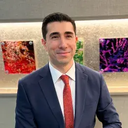 osman wears a blue blazer and red tie