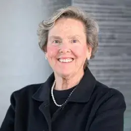 paula wears a dark suit and set of pearls