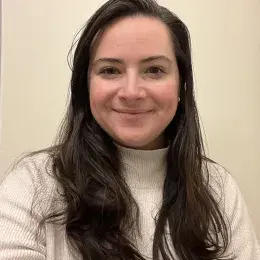 rachel has straight brown hair past her shoulders and wears a cream turtleneck sweater