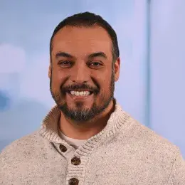 jorge has a cream colored sweater on with brown buttons