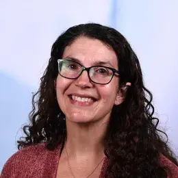 jessica has black rimmed glasses and long curly black hair