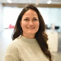 anya has a cream colored sweater and wavy brown hair past her shoulders