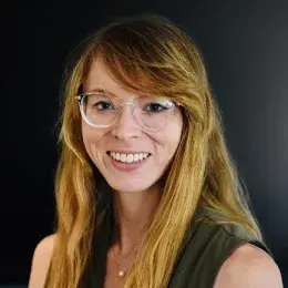 emma wears clear rimmed glasses and has strawberry blonde hair