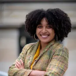 natalie wears her natural curls and gold hoop earrings