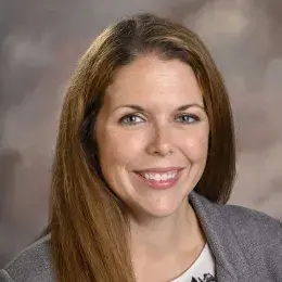 haley wears a grey blazer and has long reddish brown hair