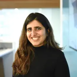 Pooja Jethani has long dark hair and is in a black shirt