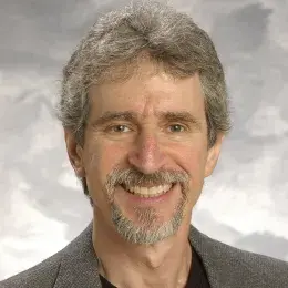 david has grey hair and goatee and wears a black shirt with a suit jacket