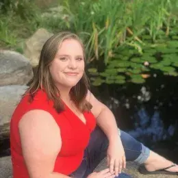 Lauren Talbourdet in red, short sleeved shirt and blue jeans. Lauren has shoulder-length, straight blonde hair.