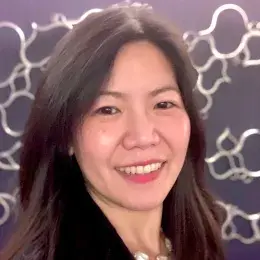 Jenny Ling Hui Loh has long dark brown hair and is wearing a black blazer and pink shirt