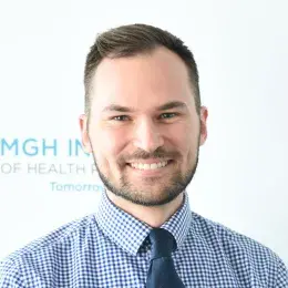 ben has a close cropped beard and mustache and wears a blue checkered shirt with a navy tie