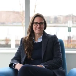 A woman sits in a chair in front of a window
