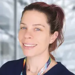 Brenna has a high ponytail and a rainbow lanyard around her neck