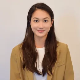 Headshot of womand with long dark hair wearing a white shirt and light brown jacket