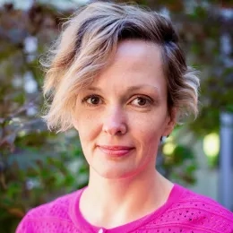 Headshot of woman with blond hair wearing pink sweater