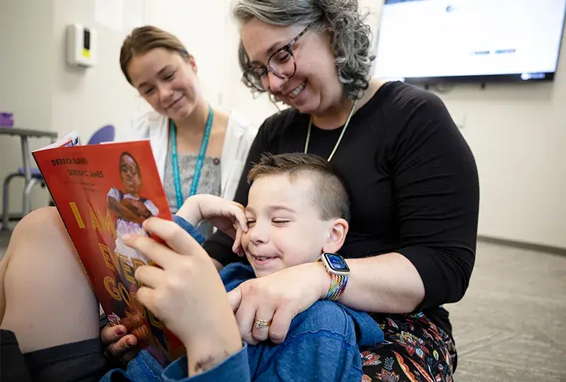 woman reads to a child in her lap