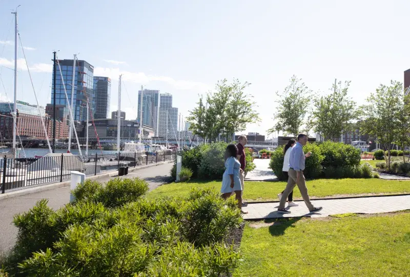 People walking in a park with the waterfront in the backround