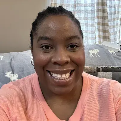 keyona wears a peach shirt and has her black hair in braids