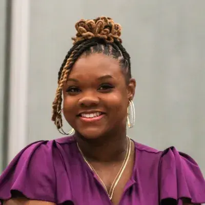 monique with a shiny purple dress and silver earrings